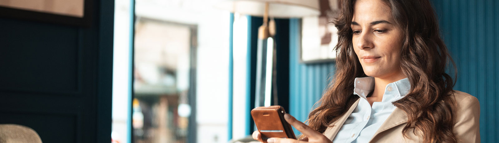 Business woman using phone in lobby